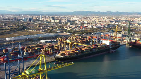 Hafen-Von-Valencia,-Riesiges-Frachtschiff,-Das-Container-Entlädt,-Spanien,-Luftaufnahme,-Sonnenuntergang